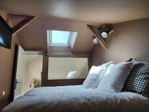 a bedroom with a large bed with a window at Cour Saint Jean in Le Neubourg