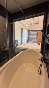 a bath tub in a bathroom with a large mirror at B Homestay in Vung Tau +9 photos