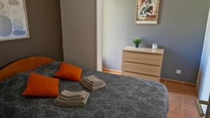 a bedroom with a bed with orange pillows and a dresser at mini villa 72, résidence avec piscine. in Serra-di-Ferro +31 photos