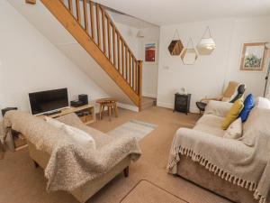 a living room with two couches and a tv at Florida Cottage in Swansea