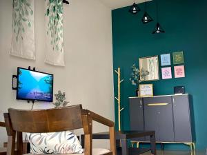 a living room with a tv and a chair at Maison Pekan in Pekan
