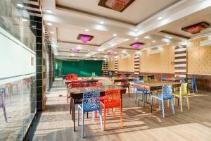 a restaurant with wooden tables and colorful chairs at Hotel O Mini Punjab Hills in Jamshedpur