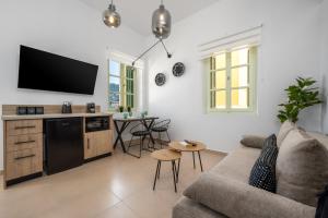 a living room with a couch and a tv at Agkyra Studio in Symi
