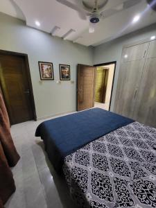 a bedroom with a blue and white bed in a room at The Home Sweet Home in Karachi
