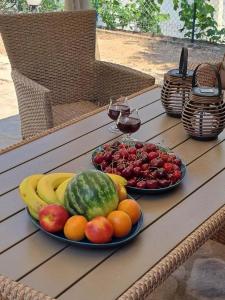 two plates of fruit on a wooden table at Vintage villa in Paleo Tsifliki