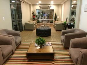 a living room with couches and a coffee table at Assi Palace Hotel in Mirassol