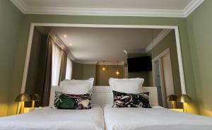 Un dormitorio con dos camas y un gran espejo. en Maison LUTETIA R, en Estrasburgo