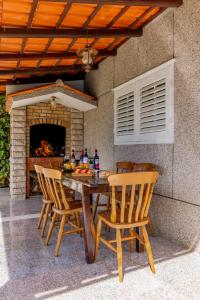 a wooden table with chairs and a fireplace at Villa Croatia with studio apartment with jacuzzi in Trogir