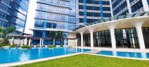 a large building with a swimming pool in front of a building at City Lights Apartment in BGC in Manila