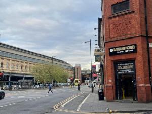 una strada cittadina con gente che cammina per strada di Rahman Hostel a Manchester