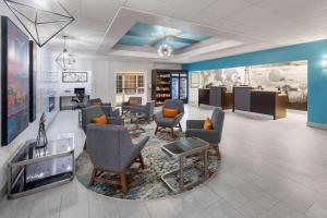 a lobby with a waiting room with chairs and tables at La Quinta by Wyndham Angleton in Angleton