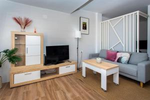 un soggiorno con un divano e una TV di Taga 27 a Torrevieja