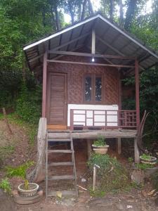 a small house with a staircase in front of it at batu putih cottage karimunjawa in Karimunjawa
