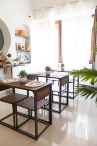 Una cocina con mesas y sillas en una habitación. en Camera Ardea, en Aversa 23 fotos más