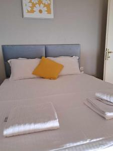 a white bed with a yellow pillow on it at Vintage villa in Paleo Tsifliki