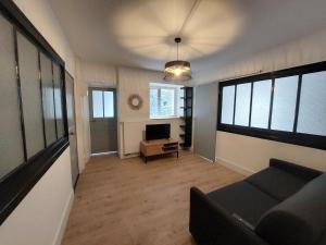 Una sala de estar con un sofá y un televisor. en Villa Jean Julien - Les Cascades - Wifi - 2 chambres - 6 personnes - Terrasse, en Le Mont-Dore