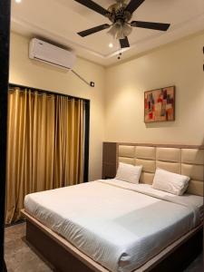 a bedroom with a bed with a ceiling fan at Riyansh Villa 5 bhk with Swimming Pool in Panchgani