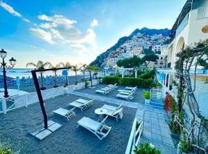 Un grupo de sillas y mesas en una playa. en La Caravella di Positano - Relais, Beach & Residences, en Positano