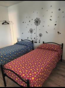 two beds in a bedroom with dandelions on the wall at villino Andrea in Anzio