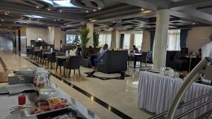 a restaurant with people sitting in chairs and tables at Grand Plaza Hotel in Kampala