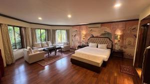 a bedroom with a king sized bed and a living room at Aayush Resort Karjat in Kālundri +88 photos