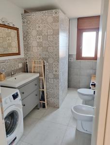 a bathroom with a washing machine and a toilet at villino Andrea in Anzio