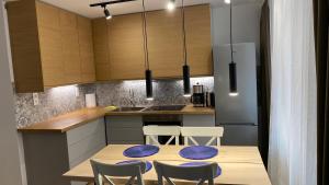 a kitchen with a table with chairs and a refrigerator at Apartament Juliana in Tarnowskie Góry