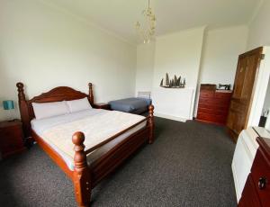 a bedroom with a wooden bed and a dresser at 1920's Comfort in Invercargill