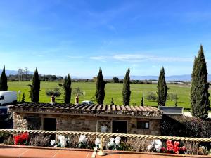a building with trees and a field in the background at Agriturismo La Rugea - Le Spighe in Prato
