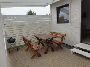 a picnic table and two benches on a patio at Domki letniskowe Jantarowa 2-1 in Chłopy