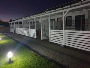 a building with a light on the grass at night at Domki letniskowe Jantarowa 2-1 in Chłopy