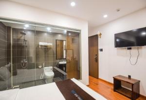 a bathroom with a shower and a toilet and a television at Bảo Anh Villa Đà Lạt in Da Lat +77 photos