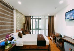 a hotel room with a bed and a television at Bảo Anh Villa Đà Lạt in Da Lat