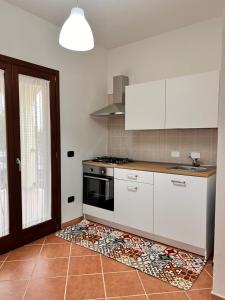 a kitchen with white cabinets and a stove at Casa Grecale in Girasole