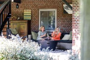 WilbertoordDe Slaaperij的两名妇女坐在天井的沙发上