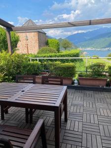 a wooden table and benches sitting on a patio at Casa Miralago - Cuasso al Monte in Cuasso Al Monte