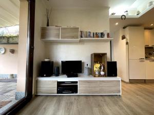 a living room with a entertainment center with a television at Casa Miralago - Cuasso al Monte in Cuasso Al Monte