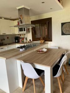 a kitchen with a wooden table and white chairs at Casa Miralago - Cuasso al Monte in Cuasso Al Monte