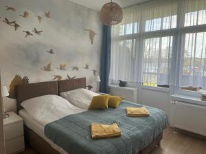 a bedroom with a bed with birds on the wall at KAMERALNY przy promenadzie - pokoje in Charzykowy