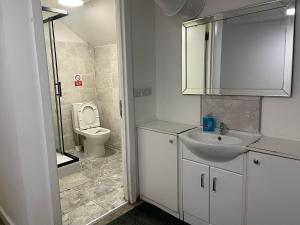 un bagno bianco con un water e un lavandino di Rahman Hostel a Manchester