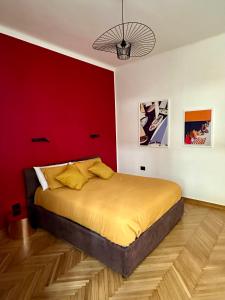 sypialnia z łóżkiem z czerwoną ścianą w obiekcie Bienbi Trieste w Trieście