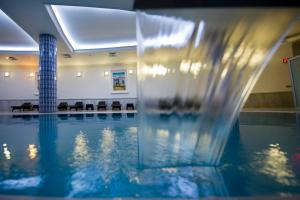 a swimming pool with a fountain in a building at The Sign Kocaeli Thermal Spa Hotel &Convention Center in Yeniköy