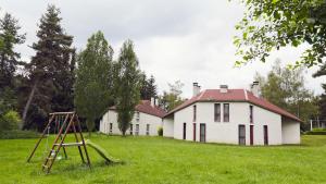 an old house with a playground in front of it at Les Gîtes du Bois de Chelles in La Chapelle-Geneste