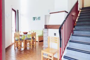a dining room and stairs with a table and chairs at Les Gîtes du Bois de Chelles in La Chapelle-Geneste