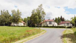 an empty road in front of two houses at Les Gîtes du Bois de Chelles in La Chapelle-Geneste