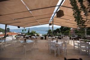 a restaurant with white tables and chairs and a view at NEFELI by Evita's Resort in Poros