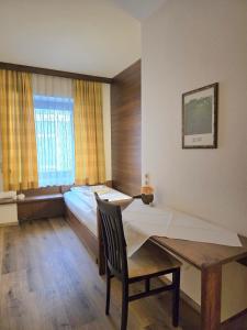 a hotel room with a bed and a table and a chair at Pension "Zum Goldenen Kreuz" in Eferding +24 photos