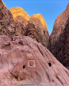 a view of a rocky mountain with dwellings on it at wadi rum luxe tours in Wadi Rum +8 photos