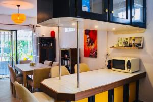 a dining room with a table with a microwave at Sands Beach Villa Flic en Flac in Flic-en-Flac