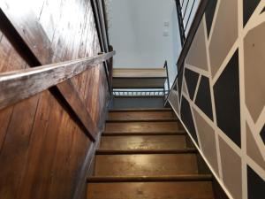 a stairway leading up to a room with wooden walls at Appartement cosy en ville avec 2 places de parking privées intérieur in Beuvrages +5 photos